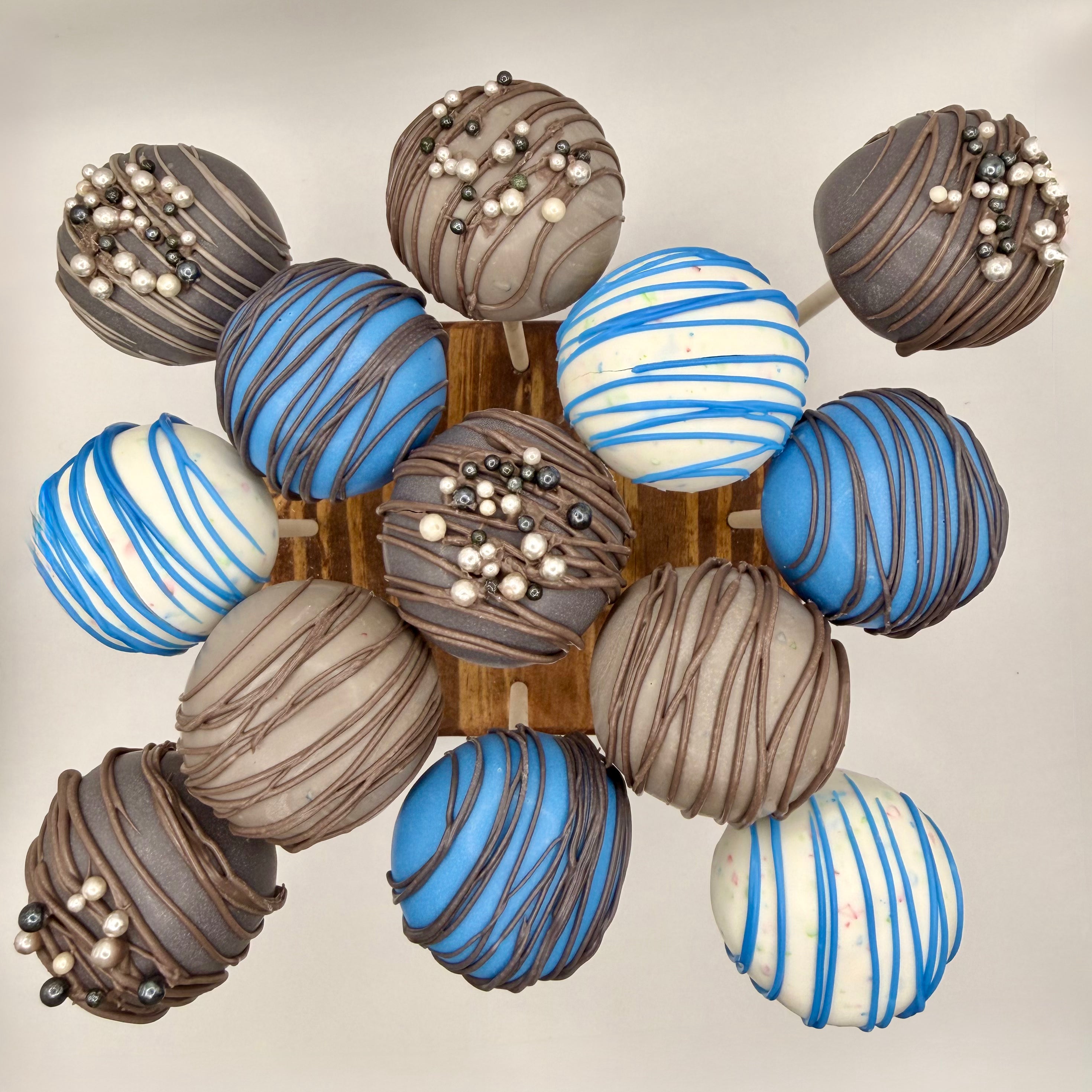 Blue, White and Brown Colored Chocolate Truffle Cake Pops With Colored Drizzle and Sprinkles. 