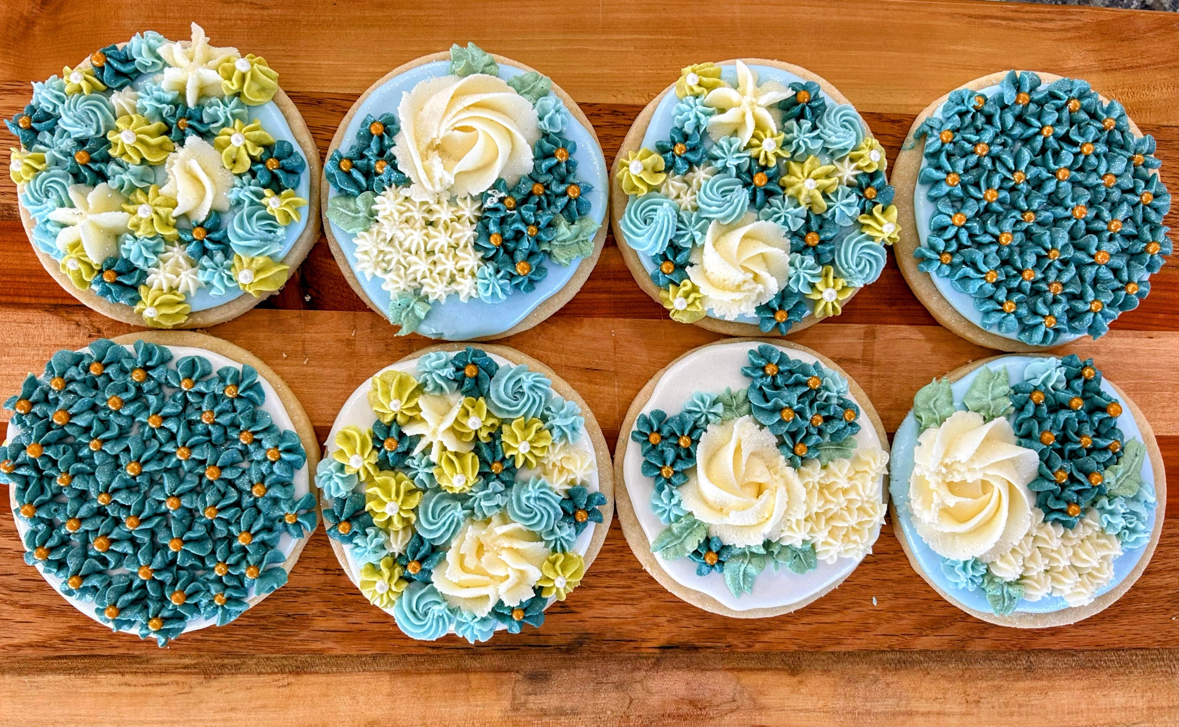 Decorative cookies with blue and white icing on a wooden surface