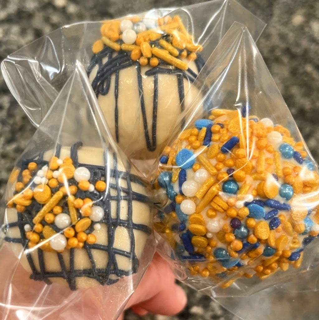 Decorative cookies with blue, orange, and white sprinkles held in clear plastic wrap.