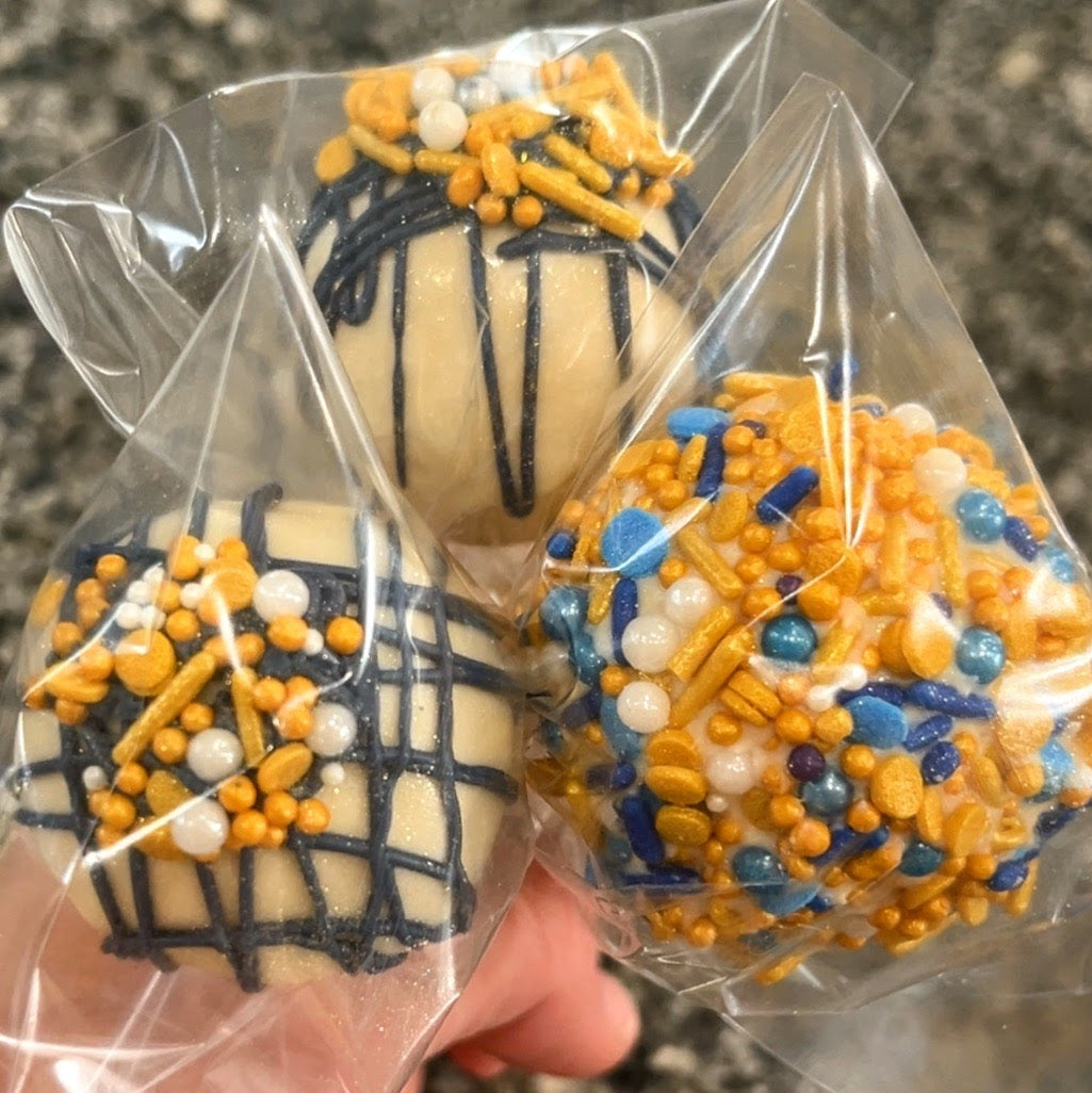 Decorative cookies with blue, orange, and white sprinkles held in clear plastic wrap.