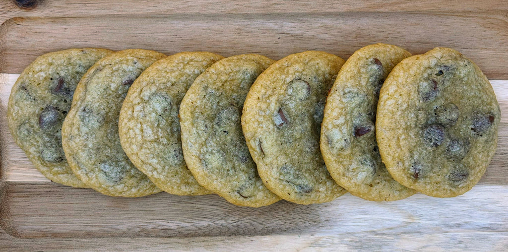 Row of chocolate chip cookies on a wooden board