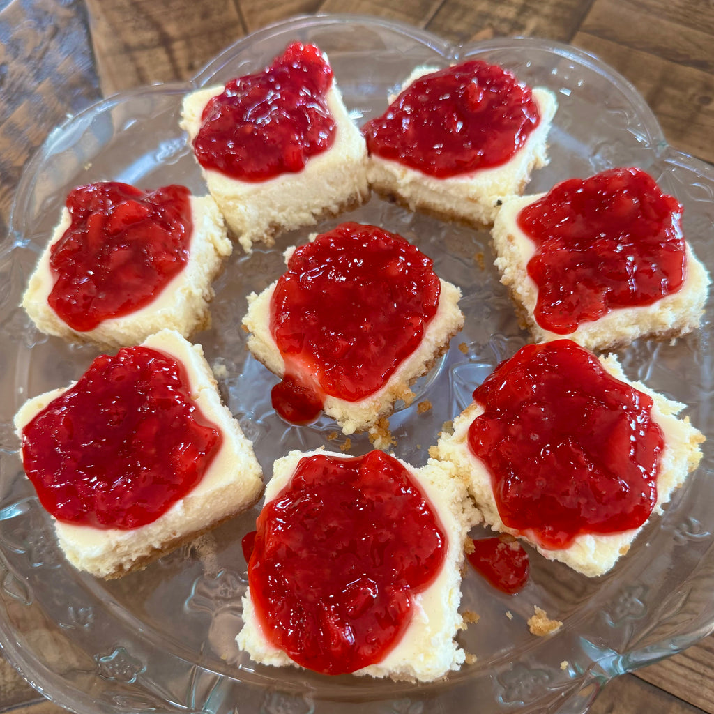 Mini square cheesecakes with red strawberry topping